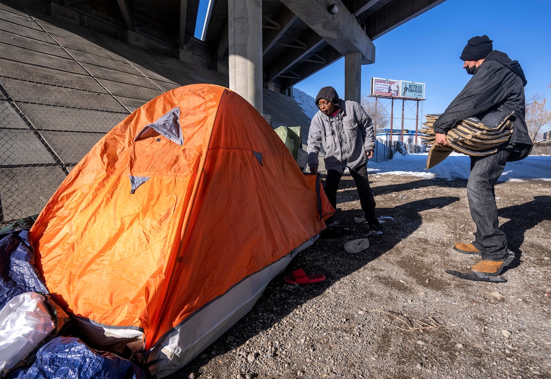 (Rick Egan | The Salt Lake Tribune) Ty Bellamy, of Black Lives for Humanity, and a volunteer named JJ distribute wool blankets donated by the Sikh community to people in camps in Salt Lake City to help the unsheltered stay warm Thursday, Dec. 23, 2021.