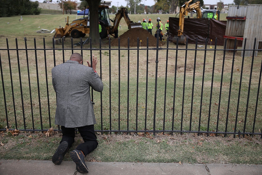 Rev. Robert Turner, with Vernon A.M.E Church, prays as crews work on a second test excavation and core sampling, Tuesday, Oct. 20, 2020, in the search for remains at Oaklawn Cemetery in Tulsa, Okla., from the 1921 Tulsa Race Massacre. (Mike Simons/Tulsa World via AP)