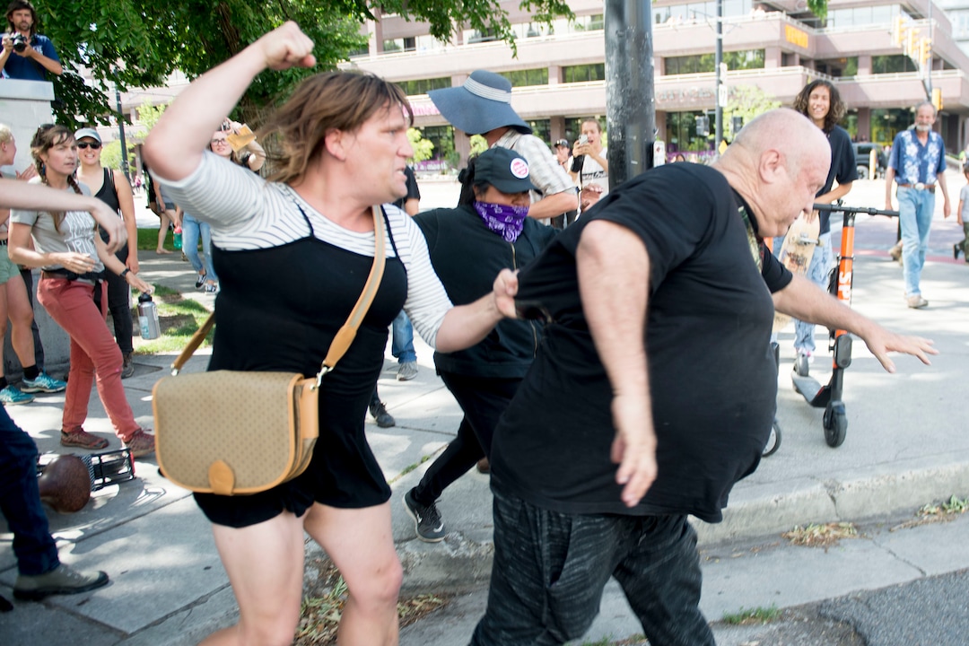 (Jeremy Harmon |  The Salt Lake Tribune) A woman attacks a man who was yelling racist taunts following an inland port protest on Tuesday, July 9, 2019.