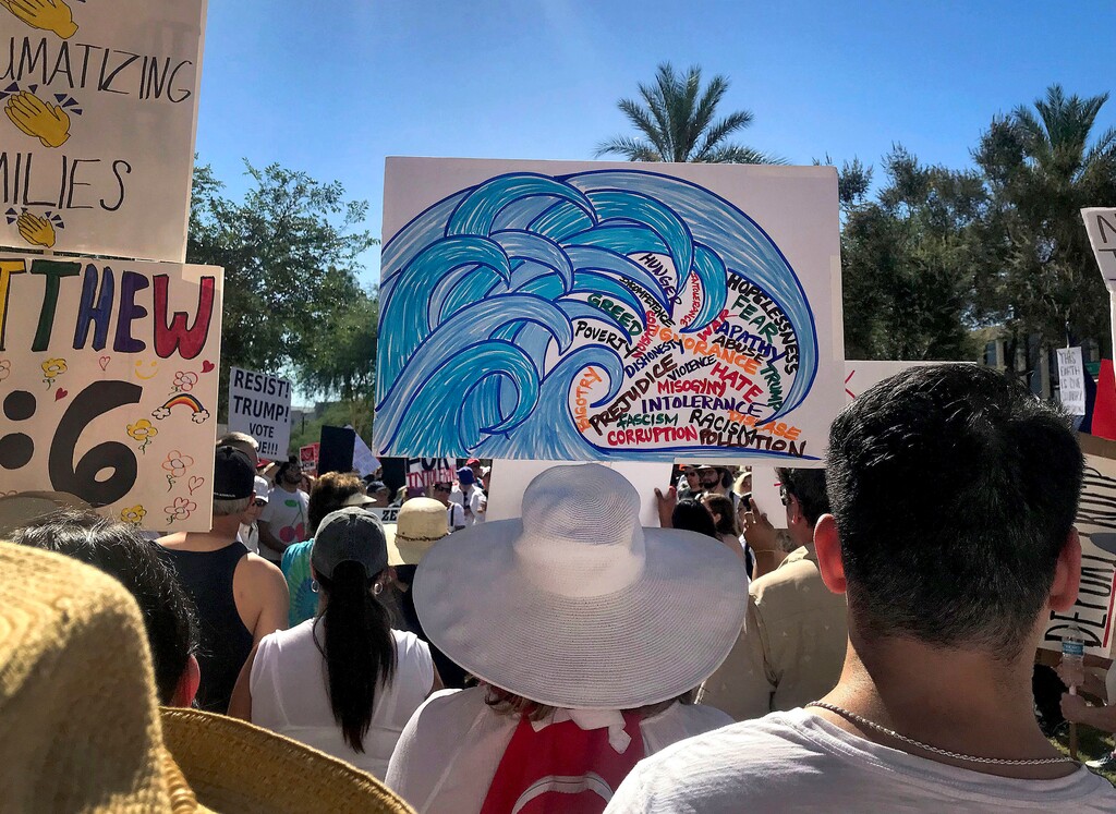 (Melissa Daniels | The Associated Press) In this June 30, 2018, photo, protesters rally at a Keep Families Together march at the Arizona state Capitol in Phoenix. The blue wave Democrats hope will crash into Arizona this November is creeping up in community centers, library auditoriums and churches.