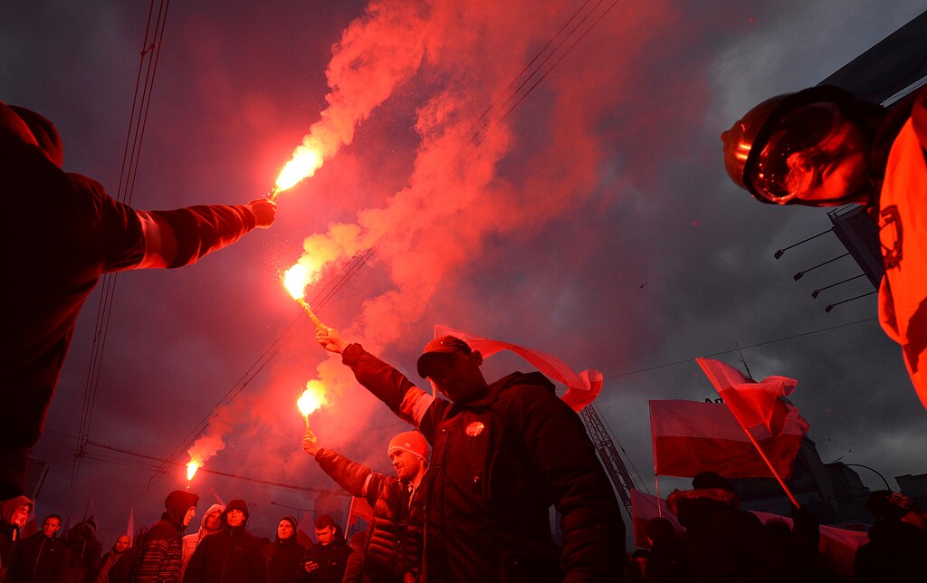 Demonstrators burn flares and wave Polish flags during the annual march to commemorate Poland's National Independence Day in Warsaw, Poland, Saturday, Nov. 11, 2017. Thousands of nationalists marched in Warsaw on Poland's Independence Day holiday, taking part in an event that was organized by far-right groups. (AP Photo/Czarek Sokolowski)