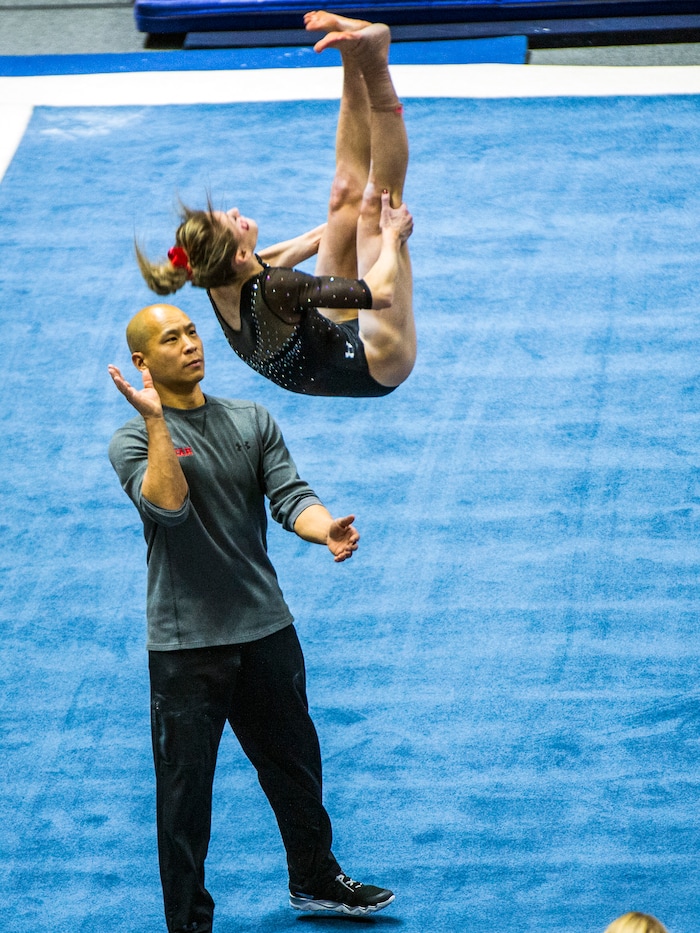 Chris Detrick  |  The Salt Lake TribuneCo-Head Coach Tom Farden helps Utah gymnast Sabrina Schwab performs her floor routine during the Red Rocks Preview at the Huntsman Center Friday December 11, 2015.  