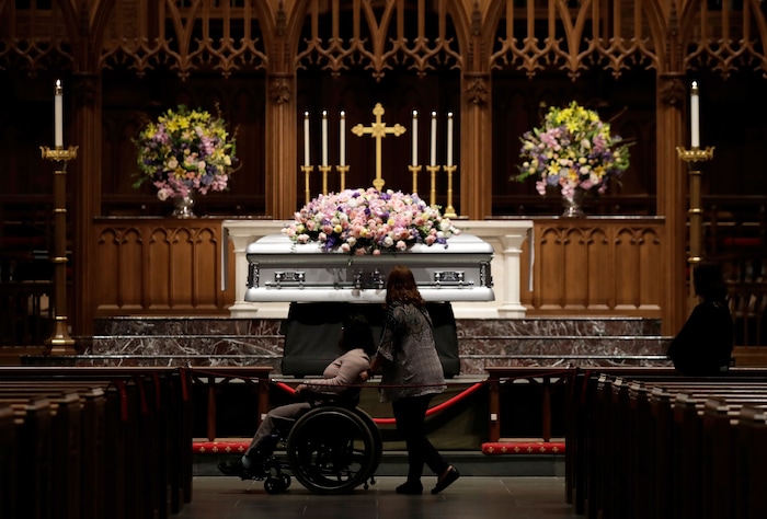 Mourners pause as former U.S. first lady Barbara Bush lies in repose during the visitation of former first lady Barbara Bush at St. Martin's Episcopal Church, Friday, April 20, 2018, in Houston. (AP Photo/Evan Vucci)