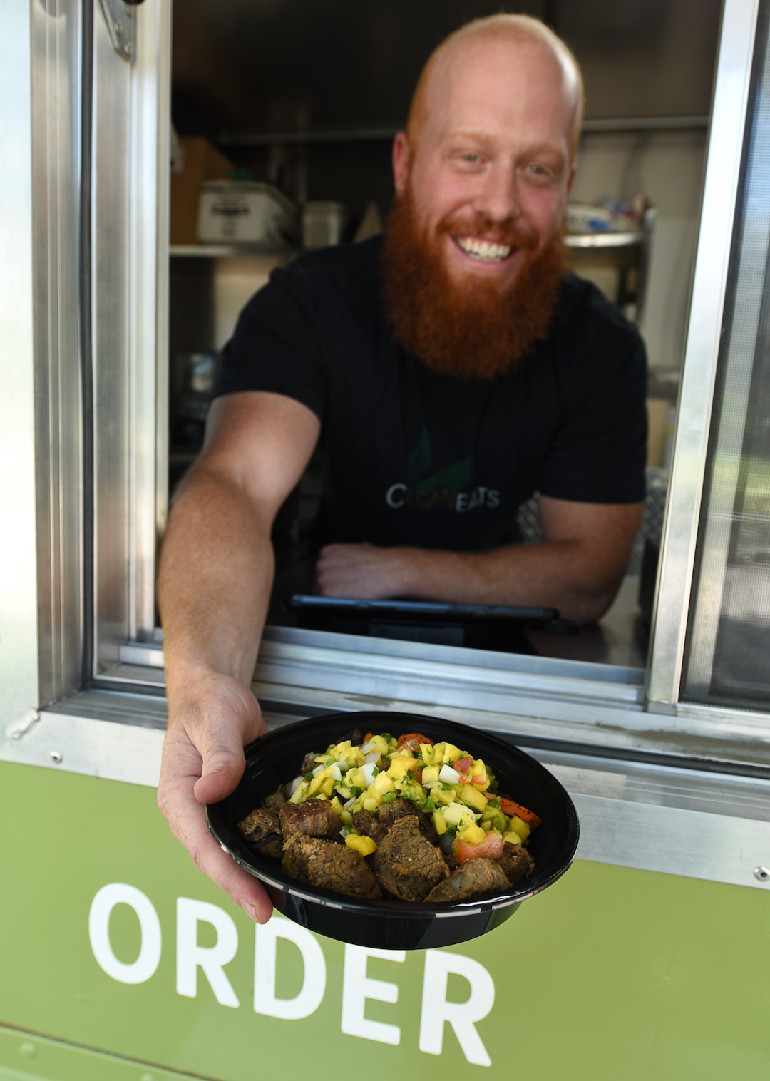 (Francisco Kjolseth  |  The Salt Lake Tribune)  Jared Trust, co-owner of Clean Eats food truck, serves his favorite  menu item steak and potatoes with a mango-jalapeno salsa