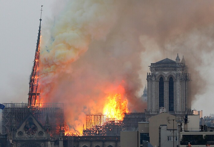 Flames rise from Notre Dame cathedral as it burns in Paris, Monday, April 15, 2019. Massive plumes of yellow brown smoke is filling the air above Notre Dame Cathedral and ash is falling on tourists and others around the island that marks the center of Paris. (AP Photo/Thibault Camus)