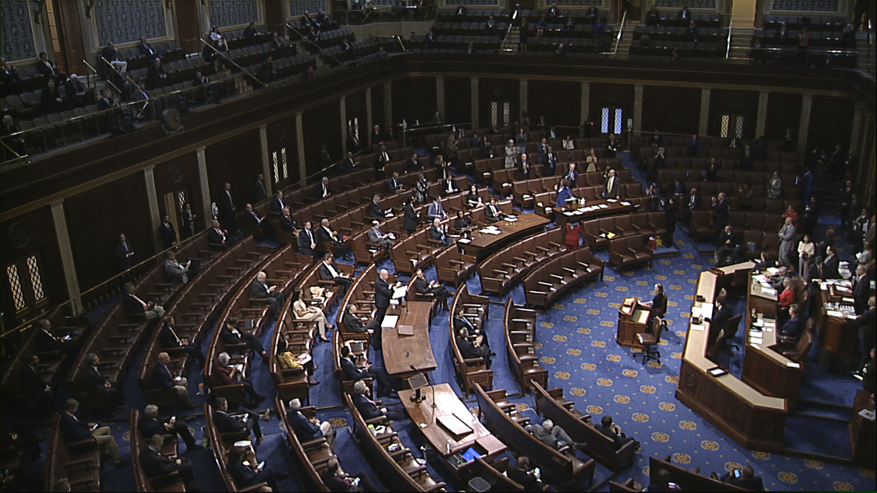 (House Television via AP) In this image from video, members of the House practice social distancing as they sit on the floor and in the public gallery above during debate on the coronavirus stimulus package on the floor of the House of Representatives at the U.S. Capitol in Washington, Friday, March 27, 2020.