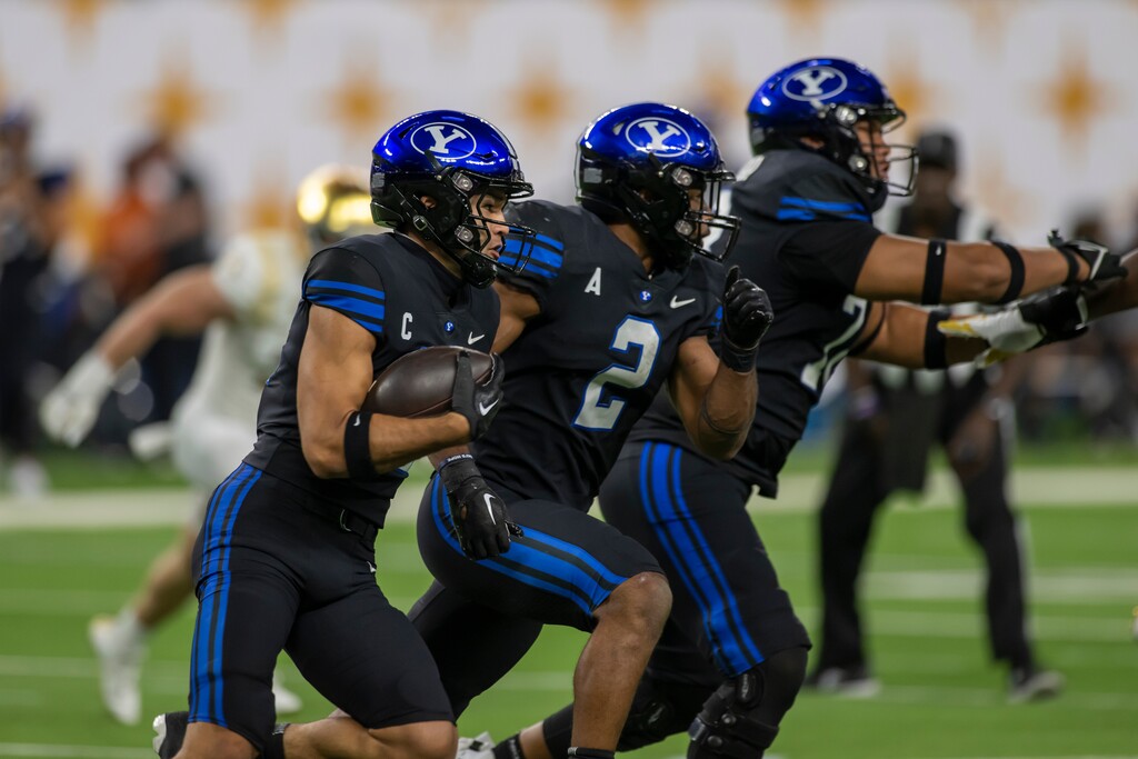 (Tyler Tate | AP) BYU Cougars wide receiver Puka Nacua, left, runs the football behind blocking teammates running back Christopher Brooks (2) and offensive lineman Vae Soifua (73) during an NCAA football game on Saturday, Oct. 8, 2022 in Las Vegas.