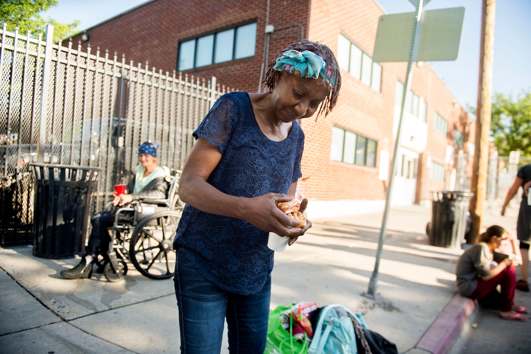 (Jeremy Harmon |  The Salt Lake Tribune) Sharon Thompson hangs on to her breakfast outside the Road Home on July 11, 2019.