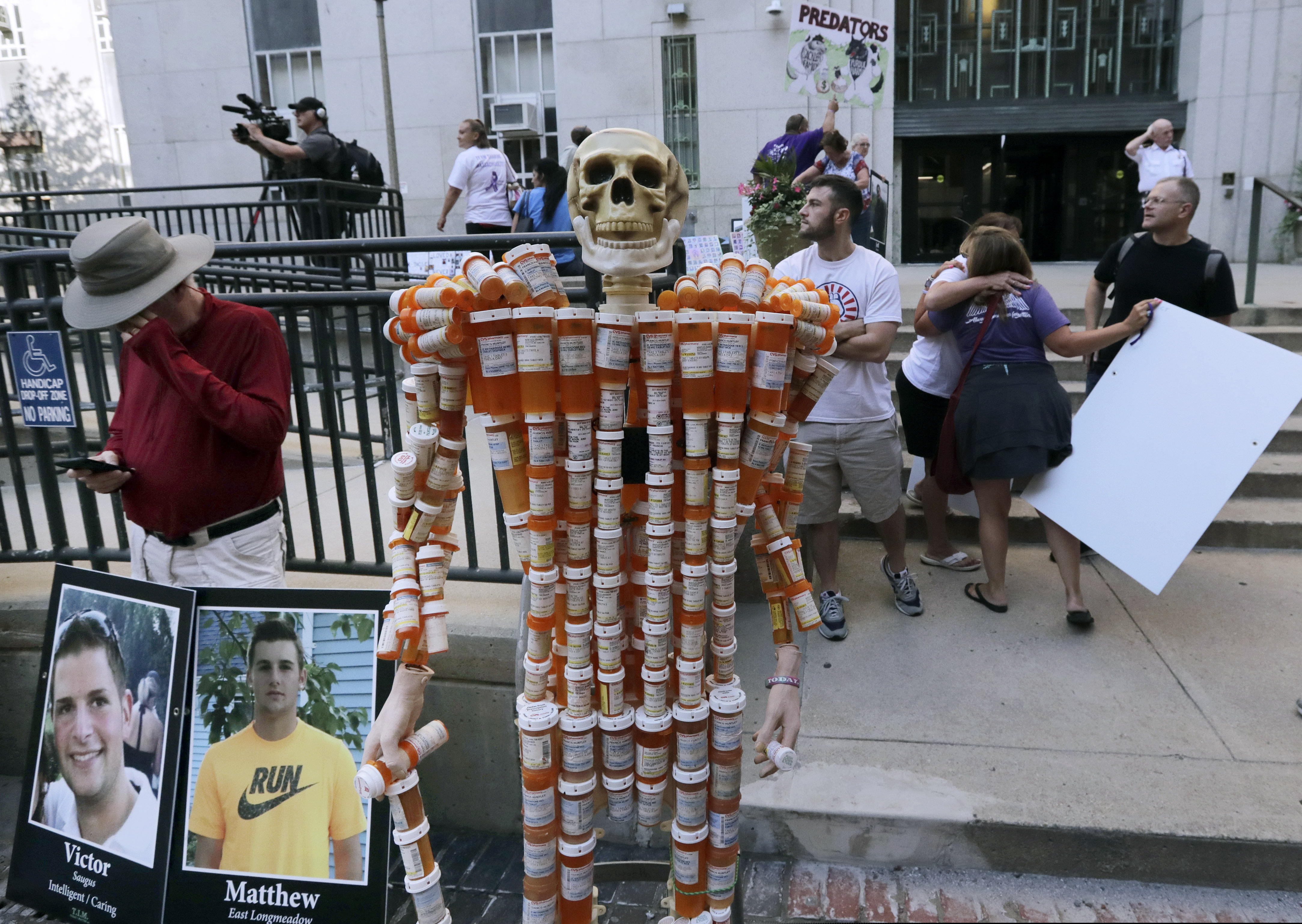 (Charles Krupa | AP Photo) A skeleton of pill bottles stands with protesters outside a courthouse on Friday, Aug. 2, 2019, in Boston, where a judge was to hear arguments in Massachusetts' lawsuit against Purdue Pharma over its role in the national drug epidemic. The skeleton was created by Frank Huntley, of Worcester, Mass., from prescriptions he said he received while addicted to opioids. Organizers of the protest said they wanted to continue to put pressure on the Connecticut pharmaceutical company and the Sackler family that owns it.