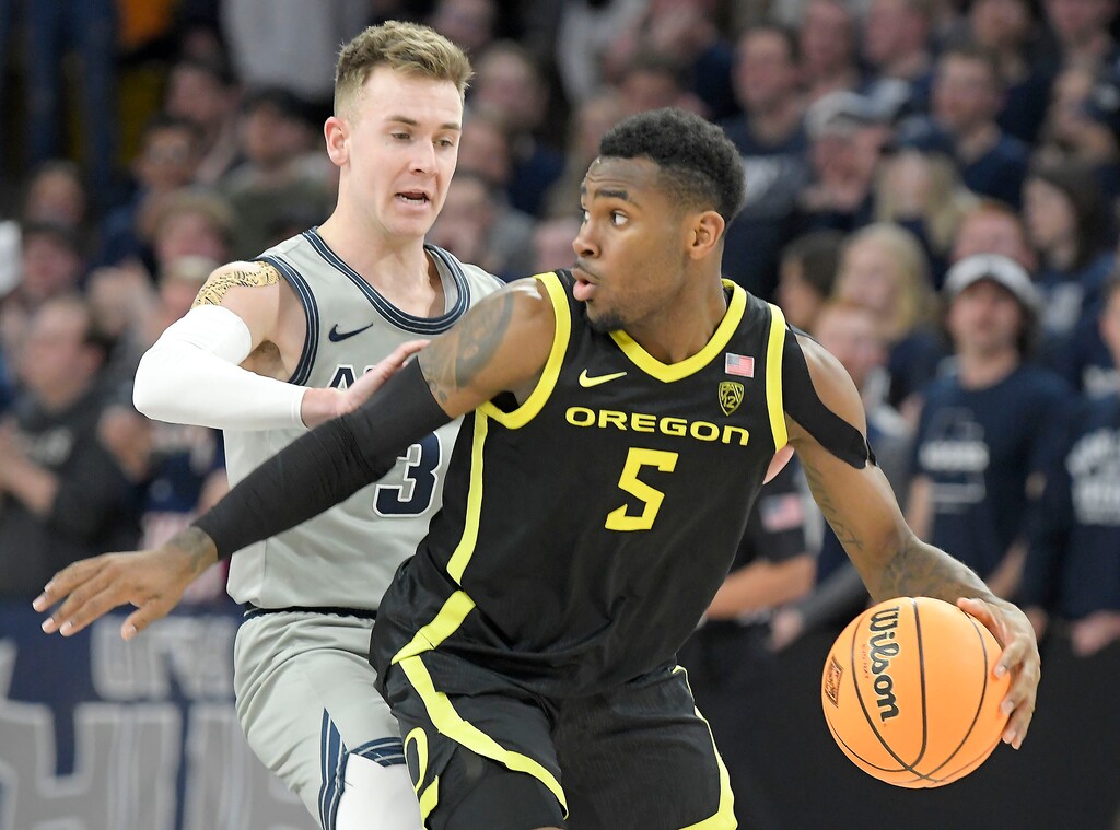 (Eli Lucero | The Herald Journal via AP) Oregon guard De'Vion Harmon (5) dribbles the ball as Utah State guard Steven Ashworth (3) defends during the opening round of the NIT on Tuesday in Logan.