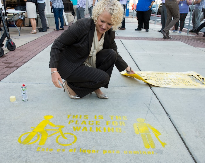 (Rick Egan  |  The Salt Lake Tribune)      Salt Lake City mayor Jackie Biskupski painted a sidewalk stencil, as Salt Lake City launches a new campaign with e-scooter companies Lime and Bird in an effort to help residents and visitors understand the rules of the sidewalk, Wednesday, Oct. 3, 2018.



