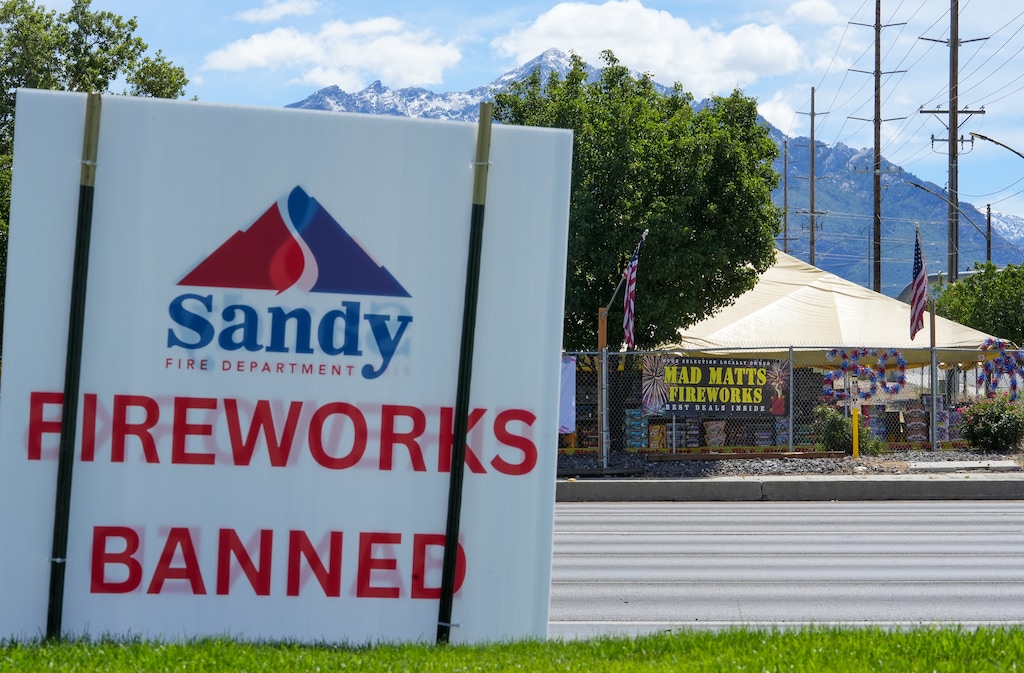(Chris Samuels | The Salt Lake Tribune) A sign from the Sandy Fire Department warning about a fireworks ban is seen across the street from Mad Matt's Fireworks in Sandy on Monday, June 29, 2026.
