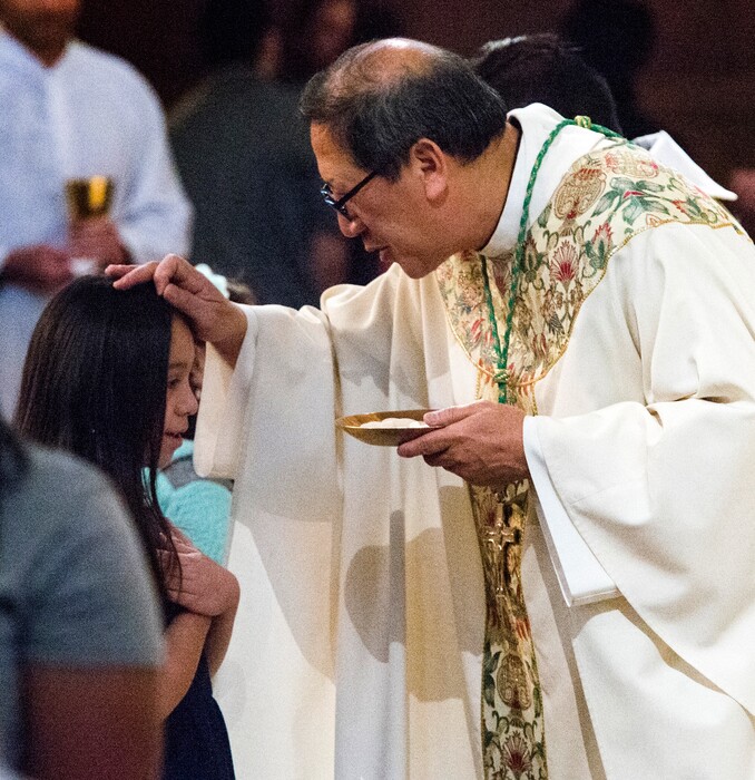 Rick Egan  |  Tribune file photo
A young girl receives Holy Communion from Bishop Oscar A. Solis during a 2017 Mass at the Cathedral of the Madeleine.