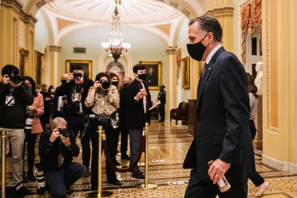 (Brandon Bell | The New York Times) Sen. Mitt Romney returns to the Senate Chamber after a break in the fourth day of former President Donald Trump’s second Senate impeachment trial at the Capitol in Washington on Friday, Feb. 12, 2021.