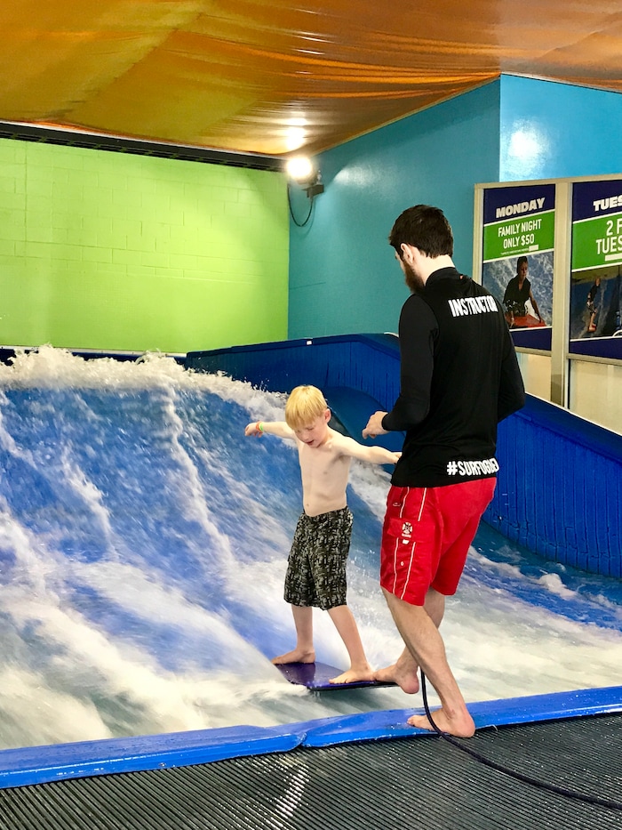 (Heather May | Special to The Tribune) Aided by instructor Jacob Berger, Luke, 8, tries surfing and boogie boarding at Flowrider in Ogden.