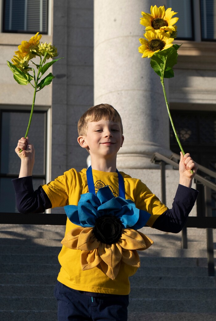 (Rick Egan | The Salt Lake Tribune) William Kutko, 5 holds sunflowers on the steps of the Capitol during a rally in support of Ukraine, on Monday, Feb. 28, 2022.