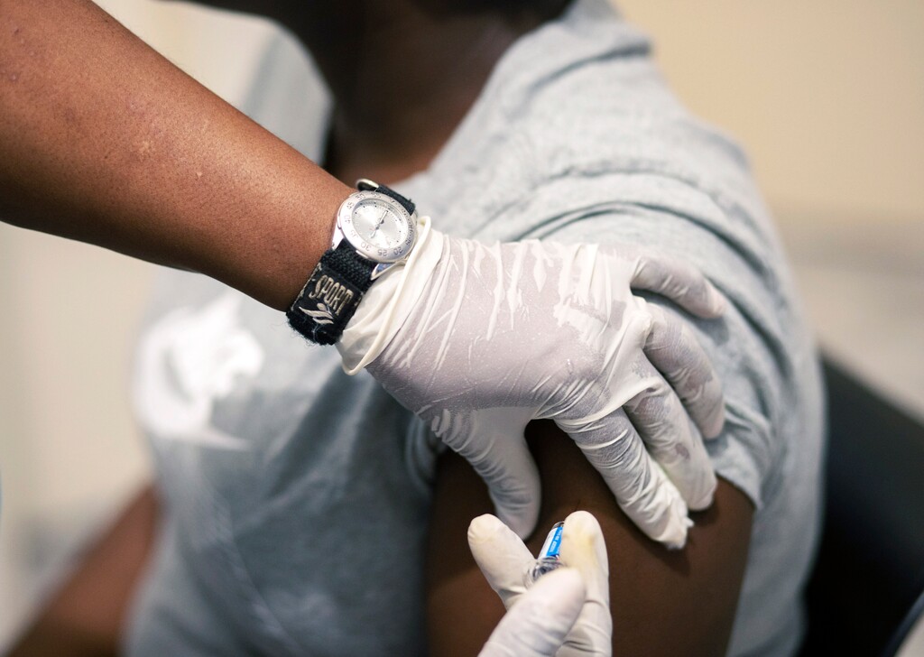 (AP Photo/Themba Hadebe) Sisi Ndebele, receives a seasonal influenza vaccine from a nurse at a local pharmacy clinic in Johannesburg, South Africa at 1800 on Friday, April 24, 2020.