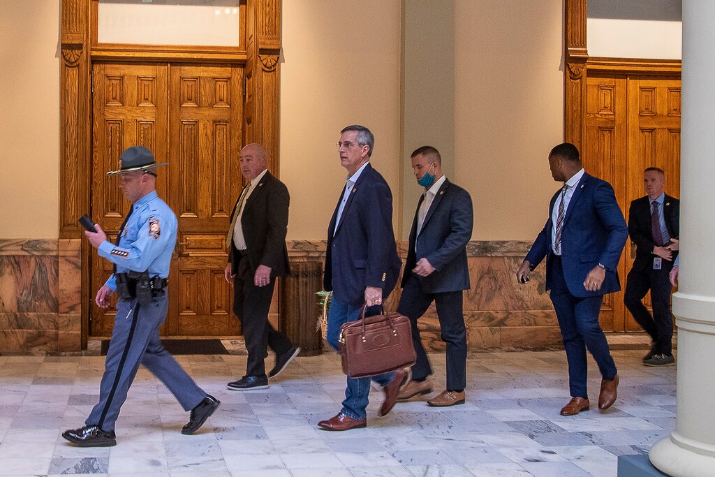 Lead by a Georgia State Trooper, Georgia Secretary of State Brad Raffensperger, center, exits the Georgia State Capitol building after hearing reports of threats, Wednesday, Jan. 6, 2021, in Atlanta. (Alyssa Pointer/Atlanta Journal-Constitution via AP)