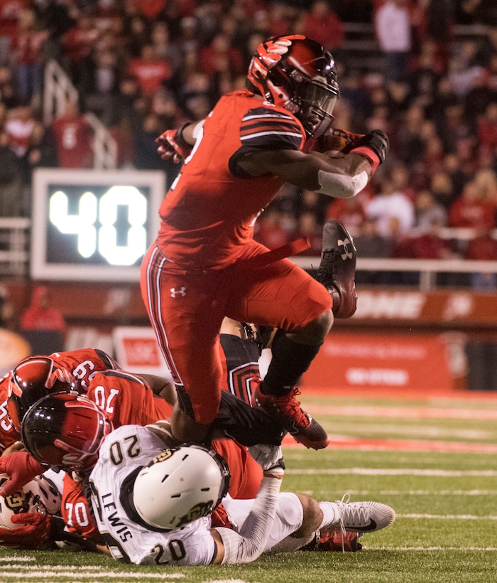 Utah running back Zack Moss (2) brakes out of the bands of Colorado Buffaloes linebacker Drew Lewis (20), as he runs the ball for the Utes, in PAC-12 football action Utah Utes vs. Colorado Buffaloes at Rice-Eccles stadium, Saturday, November 25, 2017.