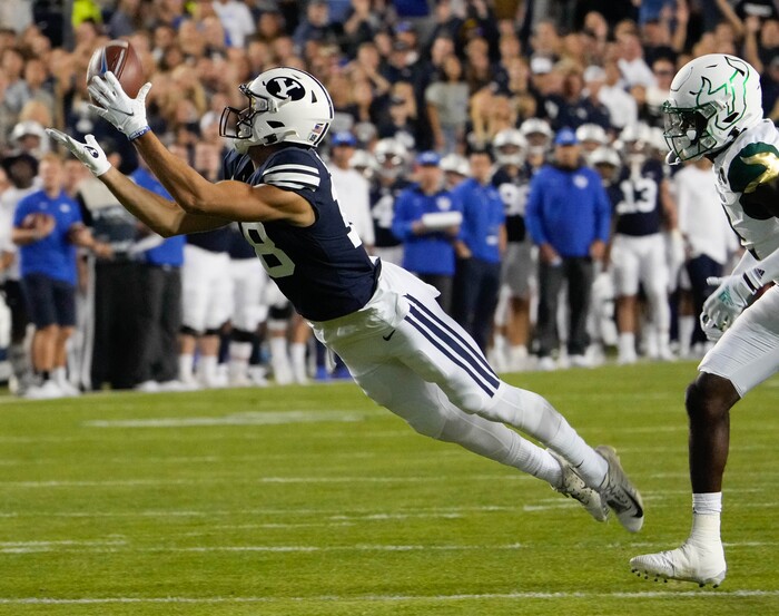 (Francisco Kjolseth | The Salt Lake Tribune) Brigham Young Cougars wide receiver Gunner Romney (18) pulls in a long pass as he’s pressured by South Florida Bulls defensive back TJ Robinson (2) in game action between the Brigham Young Cougars and the South Florida Bulls at LaVell Edwards Stadium in Provo, Saturday, Sept. 25, 2021.