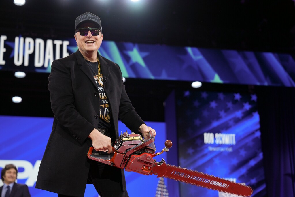 (Eric Lee | The New York Times) Elon Musk on stage with a chainsaw gifted to him by President Javier Milei of Argentina during the 2025 Conservative Political Action Conference in National Harbor, Md., on Thursday, Feb. 20, 2025.