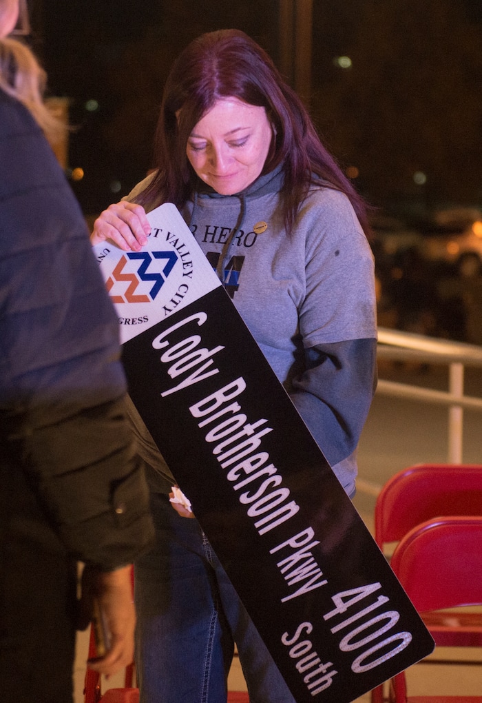 (Rick Egan  |  The Salt Lake Tribune)  Jenny Brotherson, mother of Cody Brotherson, looks at a street sign during a memorial ceremony at Fairbourne Station Plaza in West Valley City, in remembrance of her son Cody, who was killed in the line of duty one year ago today. It was announced tonight that West Valley will name 4100 South Cody Brotherson Parkway. Monday, November 6, 2017.