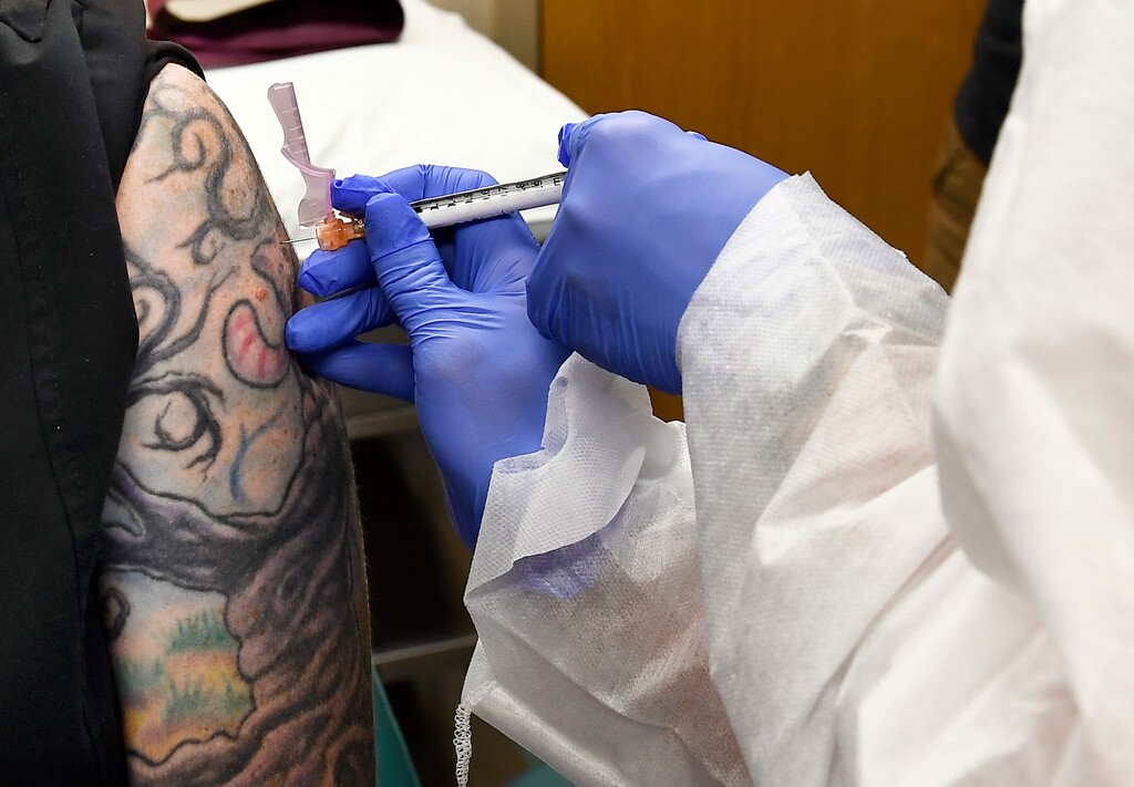 (AP Photo/Hans Pennink, File) In this July 27, 2020, file photo, nurse Kathe Olmstead, right, gives volunteer Melissa Harting, of Harpersville, N.Y., an injection as a study of a possible COVID-19 vaccine, developed by the National Institutes of Health and Moderna Inc., gets underway in Binghamton, N.Y.