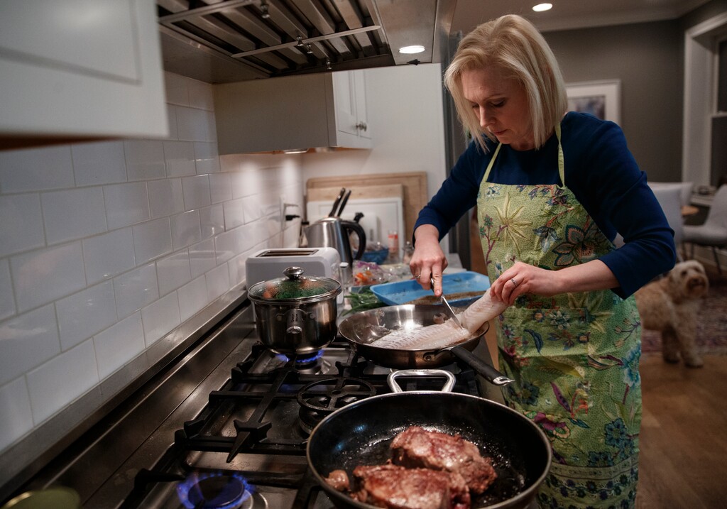 Sen. Kirsten Gillibrand, D-N.Y., cooks steak and fish for dinner at her home in Washington, Tuesday, Feb. 12, 2019. Gillibrand isn’t just embracing her role as a mother on the campaign trail, she's running on it. She opens her stump speech declaring she will “fight for your children as hard as I would fight for my own.” (AP Photo/Carolyn Kaster)
