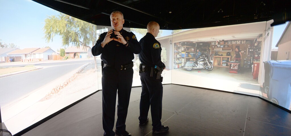 (Steve Griffin  |  The Salt Lake Tribune)  Provo City Police Chief John King, left, talks about reacting to scenarios as Provo City Police detective Daniel Pust listens following a scenario where he was forced to shoot a suspect  in the VIRTRA 300 training system in a NuSkin owned building located at 244 W 100 S in Provo, Utah Monday, April 18, 2016. Largely due to the efforts of State Representative Keven Stratton, the law enforcement agencies of Utah County received a grant to purchase the realistic, 300 degree training simulator with five floor to ceiling video screens that are set up in a circle. The screens portray a variety of potentially stressful situations that officers find themselves in daily. These scenarios test officersÕ decision making skills providing only seconds to decide how to react. 