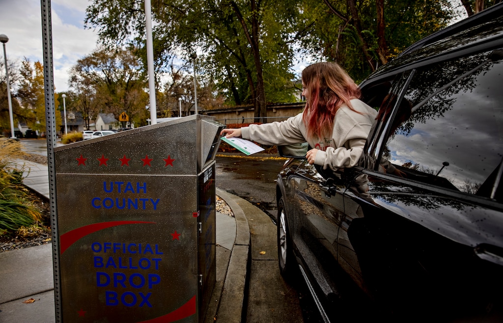 (Kim Raff | The New York Times) A voter drops off their ballot at a ballot drop box on Election Day outside the American Fork Library in American Fork, Nov. 8, 2022.