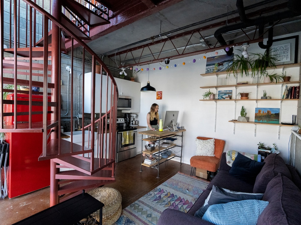 (Leah Hogsten | The Salt Lake Tribune) "It's perfect for me," said Riley Finnegan, 27, of her 346-square-foot Broadway Park Lofts condominium, Wednesday, June 1, 2022. Finnegan works remotely at her computer on a kitchen island stand she and her father made.