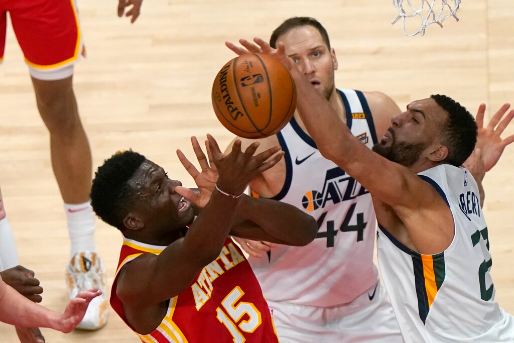 Atlanta Hawks center Clint Capela (15) battles Utah Jazz center Rudy Gobert (27) and Bojan Bogdanovic (44) for a rebound in the first half of an NBA basketball game Thursday, Feb. 4, 2021, in Atlanta. (AP Photo/John Bazemore)