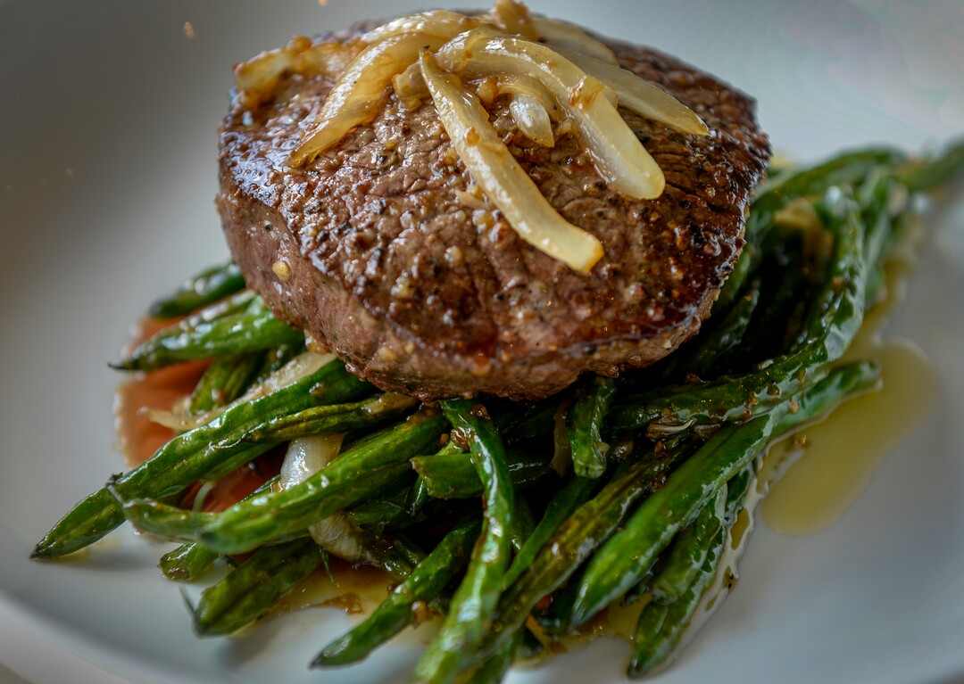 (Leah Hogsten  |  The Salt Lake Tribune)  Saola filet mignon, covered with garlic butter and onions served over blistered green beans, $34. Saola restaurant, located in Cottonwood Heights, serves Vietnamese food using locally sourced ingredients.