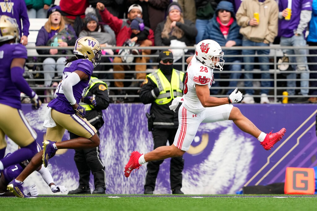 Utah running back Sione Vaki, right, scores a touchdown in front of Washington safety Vincent Nunley during the first half of an NCAA college football game Saturday, Nov. 11, 2023, in Seattle. (AP Photo/Lindsey Wasson)