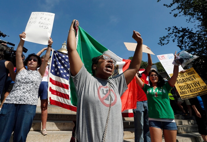 Counterprotesters hold signs and chant at the Statehouse before a planned "Free Speech" rally by conservative organizers begin on the adjacent Boston Common, Saturday, Aug. 19, 2017, in Boston.  Police Commissioner William Evans said Friday that 500 officers, some in uniform, others undercover, would be deployed to keep the two groups apart.  (AP Photo/Michael Dwyer)