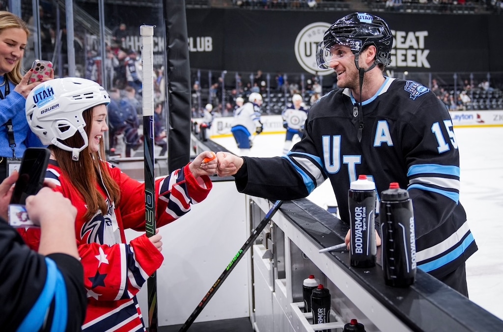 (Hunter Dyke, Kristi Davis) Alex Kerfoot interacts with a youth female hockey player during Utah's warmups at Delta Center.