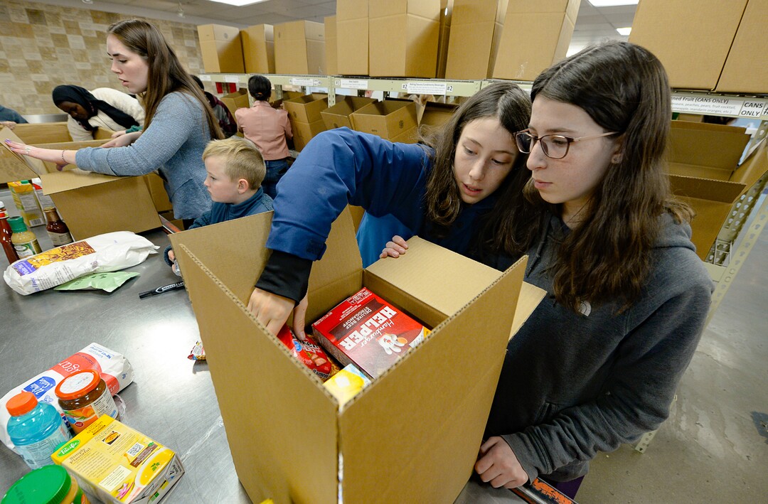 (Francisco Kjolseth  |  The Salt Lake Tribune) Siblings Alex Briefer, 12, center left, and his sister Amelia, 14, help assemble the proper proportions of food into a box while volunteering at the Utah Food Bank on Monday, Jan. 20, 2020, to celebrate the 2020 Martin Luther King Jr. Day of Service.