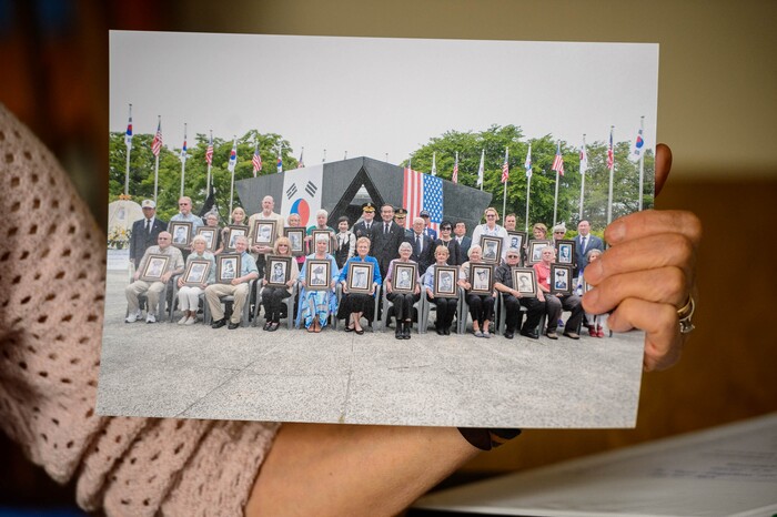 (Trent Nelson  |  The Salt Lake Tribune) Family members of Korean War veterans are honored at a war memorial during a trip to South Korea in a photograph held by Sunny Lee. Lee works with the South Korean government to bring the families of MIA Korean War veterans to South Korea where they are honored for their family member's service. Lee was photographed at her Springdale home on Tuesday, May 19, 2020.