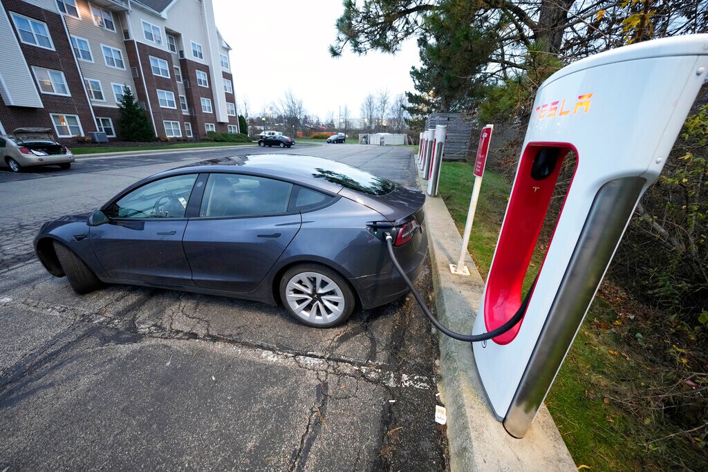 (Gene J. Puskar | AP File) A Tesla sedan gets a charge at a Tesla Supercharging station in Cranberry, Pa, Wednesday, Nov. 16, 2022. With its sales slowing and its stock price tumbling, Tesla Inc. slashed prices dramatically Friday on several versions of its electric vehicles, making some of its models eligible for a new federal tax credit that could help spur buyer interest.