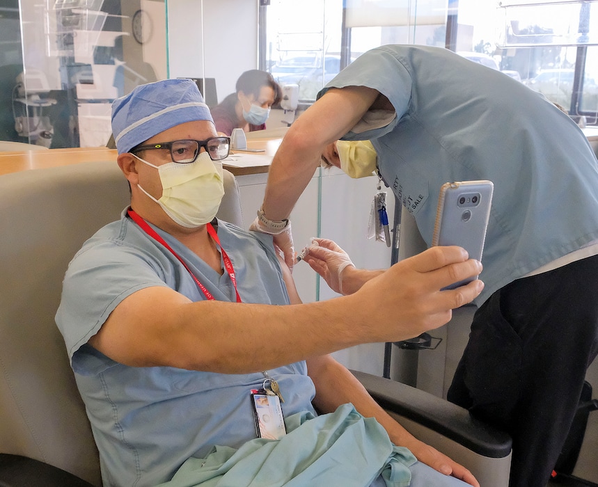 (Leah Hogsten | The Salt Lake Tribune) Roger, a nurse anesthetist at the Veterans Affairs Medical Center who declined to give his last name, takes a selfie as he receives the COVID-19 vaccine on Wednesday. Salt Lake City's George E. Wahlen VA Medical Center is one of 113 VA medical centers across the country to receive the first limited supply of the Moderna COVID-19 vaccine. As frontline health care workers in Utah hospitals continue to get vaccinations this week, those who work at long-term care facilities are scheduled to get their first doses Monday.