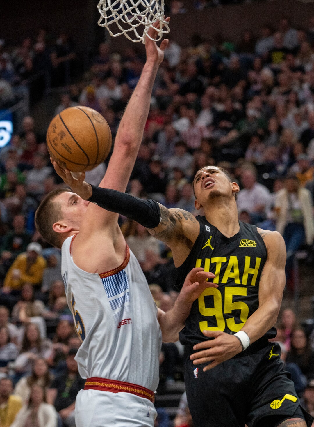 (Rick Egan | The Salt Lake Tribune) Utah Jazz forward Juan Toscano-Anderson (95) goes for a revers layup as Denver Nuggets center Nikola Jokic (15) defends, in NBA action between the Utah Jazz and the Denver Nuggets at Vivint Arena,  Saturday, April 8, 2023.