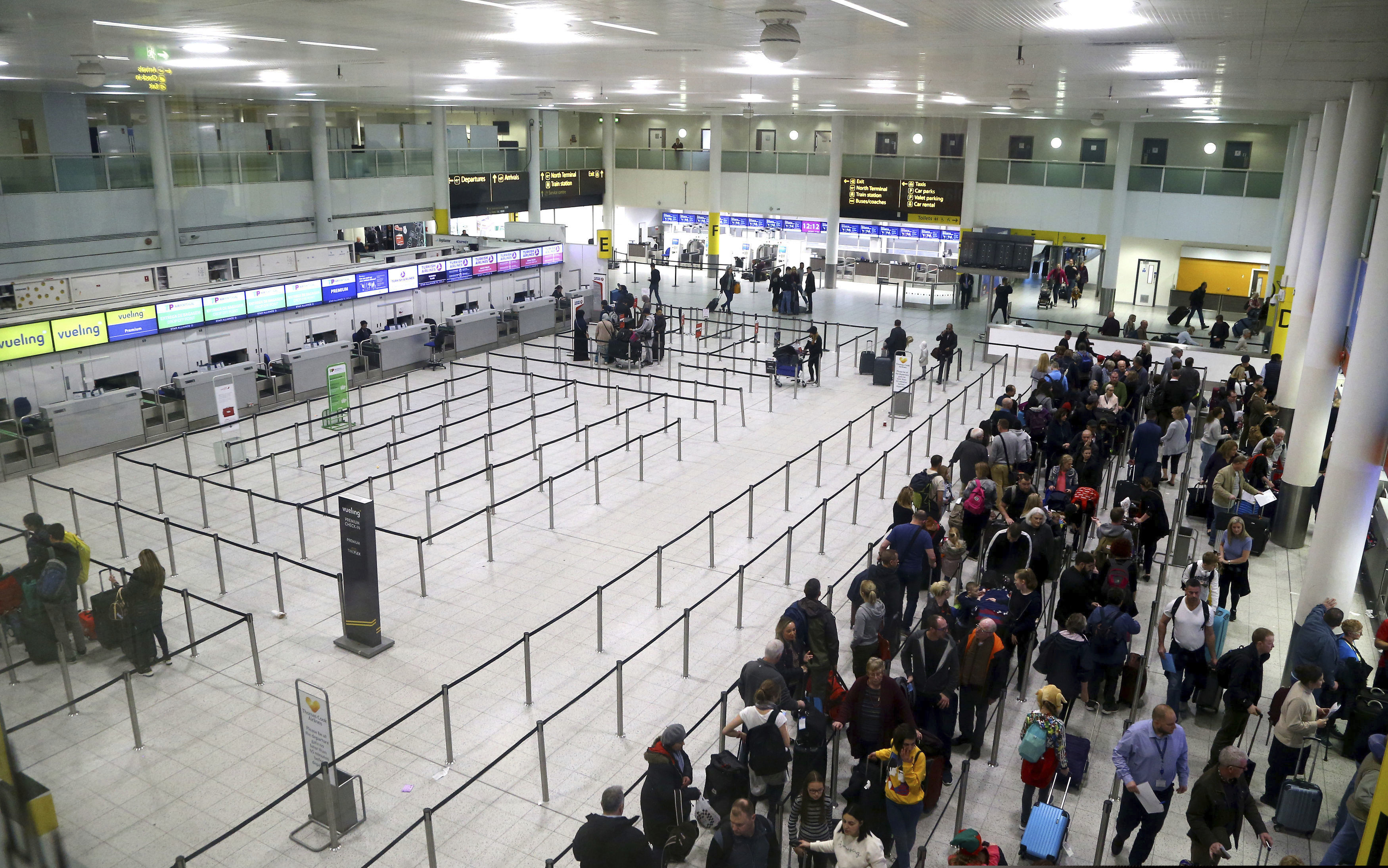 (Gareth Fuller/PA via AP) Passengers queue for flights at Gatwick Airport as the airport and airlines work to clear the backlog of flights delayed by a drone incident earlier in the week, in Crawley, England, Saturday, Dec. 22, 2018. London's Gatwick Airport took strides toward running a full schedule Saturday as police questioned a man and a woman in connection with the drone intrusions that caused mayhem for tens of thousands of holiday travelers.