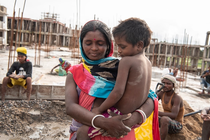(Saumya Khandelwal | The New York Times) Rabita spends time with her youngest son, Sumari, at the construction site where she and her husband both work and live in Lucknow, India, July 24, 2020. Around the world, the poor and marginalized are much more likely to be vulnerable to extreme heat; Rabita and her husband are Dalits, at the bottom of the Hindu caste ladder, working to pay off their debts.
