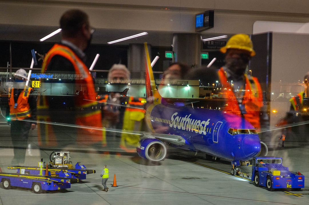 (Trent Nelson  |  The Salt Lake Tribune) Workers reflected in the window look on as the first flight from concourse B at the Salt Lake City International Airport, a Southwest flight to Oakland, prepares to take off on Tuesday, Oct. 27, 2020.