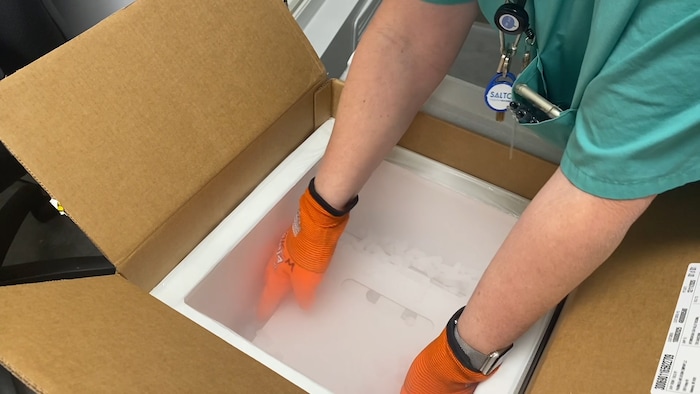 (Photos courtesy Intermountain Healthcare) An employee at Utah Valley Hospital in Provo unboxes the state of Utah's first batch of COVID-19 vaccine, on Monday, Dec. 14, 2020. The vaccine, developed by Pfizer Inc. and BioNTech, must be stored at around 95 degrees below zero Fahrenheit, so it is shipped surrounded by dry ice and stored in a supercold freezer.
