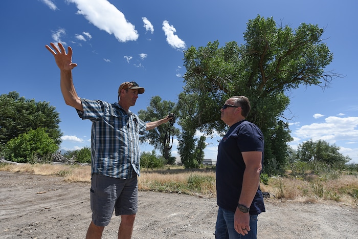 (Francisco Kjolseth | The Salt Lake Tribune) Tim Begue, left, a self described birder since 1994, talks with Chris Mantas, the owner of All Truck & Car auto recycling who is constructing a new facility at 3255 W. 500 South. Mantas originally planned to rip out the large cottonwood trees in the background to make way for his new business. Neighbors persuaded him to save the habitat.