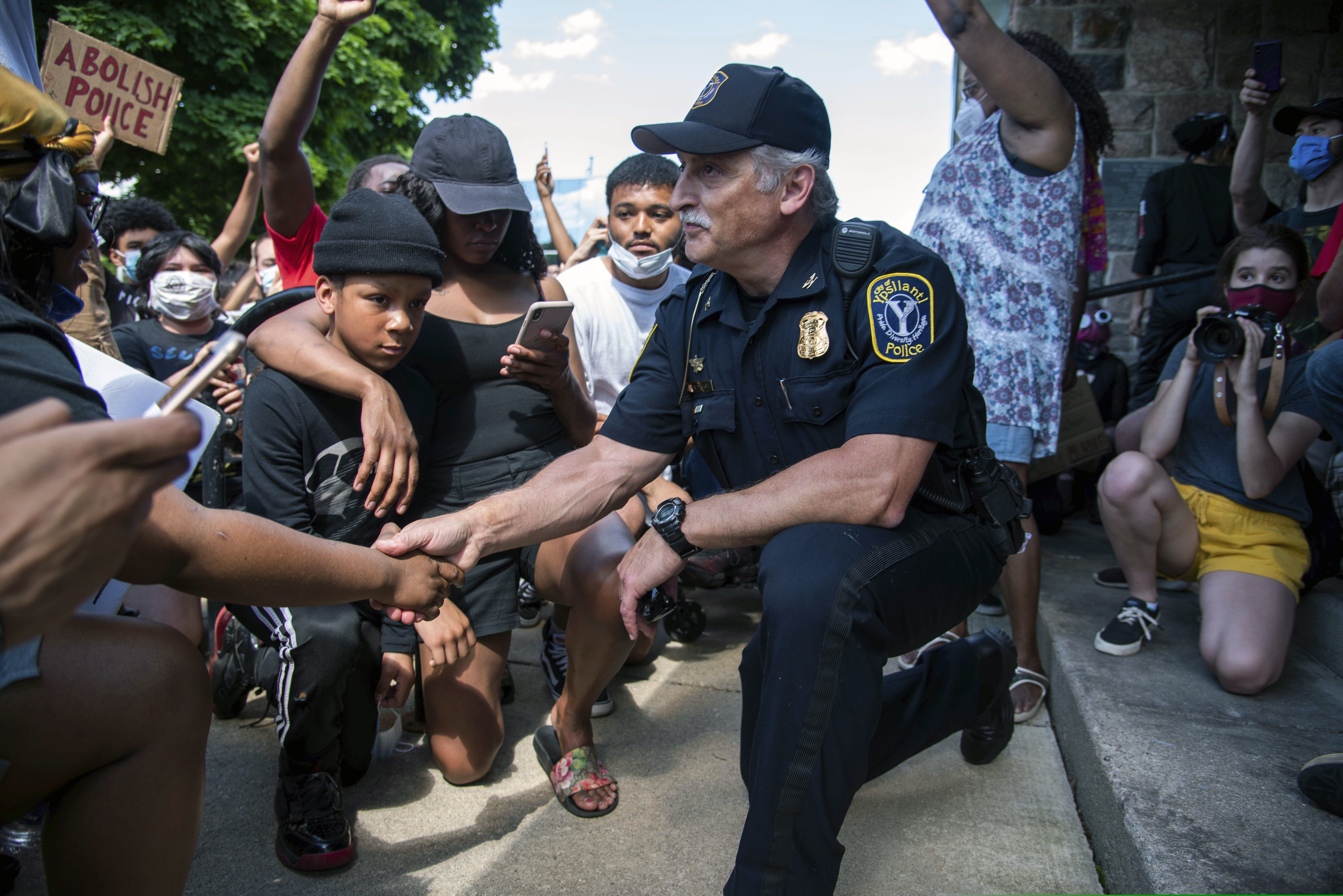 (Jenna Kieser | Ann Arbor News via AP)
Ypsilanti, Michigan Police Chief Tony DeGiusti shakes hands with a protester while taking a knee with demonstrators in a moment of solidarity during a police brutality protest in downtown Ypsilanti, Mich., Saturday, June 6, 2020.