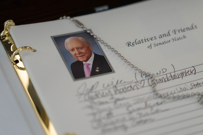 (Francisco Kjolseth | The Salt Lake Tribune) People sign the guest book as the casket carrying former U.S. Sen. Orrin Hatch lies at the Utah Capitol on Wednesday, May 4, 2022.