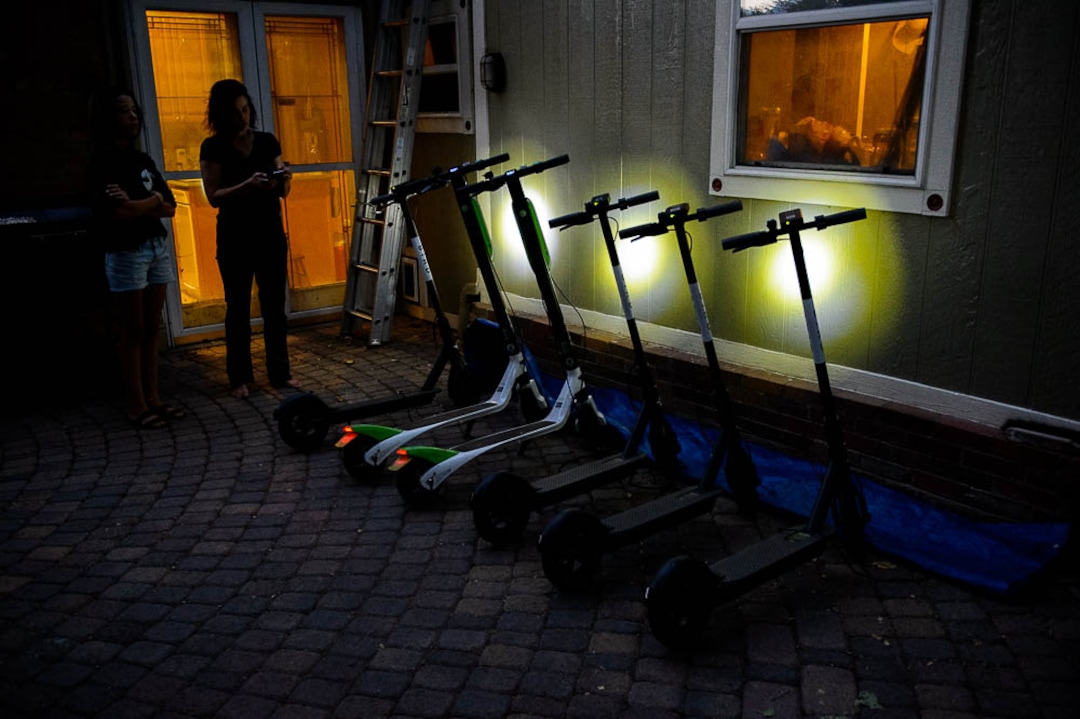 (Trent Nelson | The Salt Lake Tribune) Jenn Hein checks the status of scooters left to charge overnight as she prepares to return them to downtown Salt Lake City locations early Wednesday Aug. 8, 2018. At left is her daughter Ady Hein.