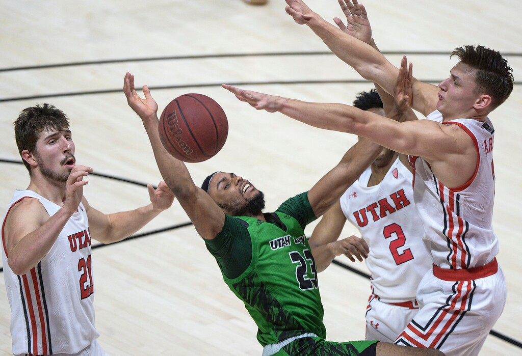 (Leah Hogsten  |  The Salt Lake Tribune) Utah Valley Wolverines guard Jordan Brinson (23) is fouled by Utah Utes guard Pelle Larsson (3) as the Utes host Utah Valley University on Tuesday, Dec. 15, 2020 at the Jon M. Huntsman Center.